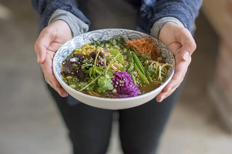 Woman holding a bowl with food - Big Dog Cafe Menu - Terbodore